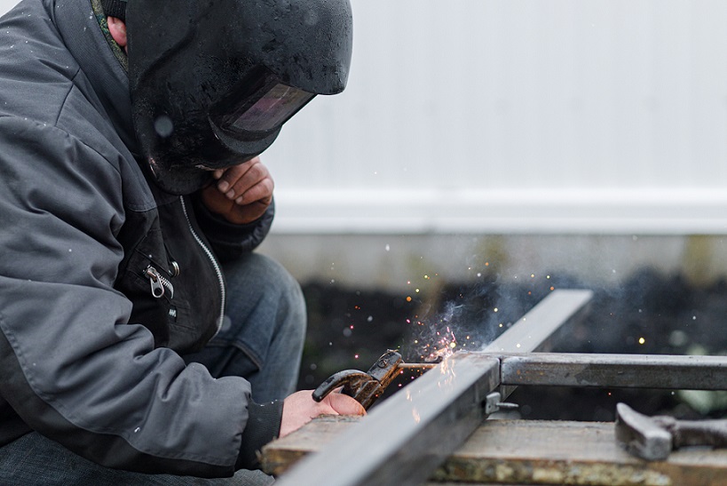 Man wearing safety gear holding torch