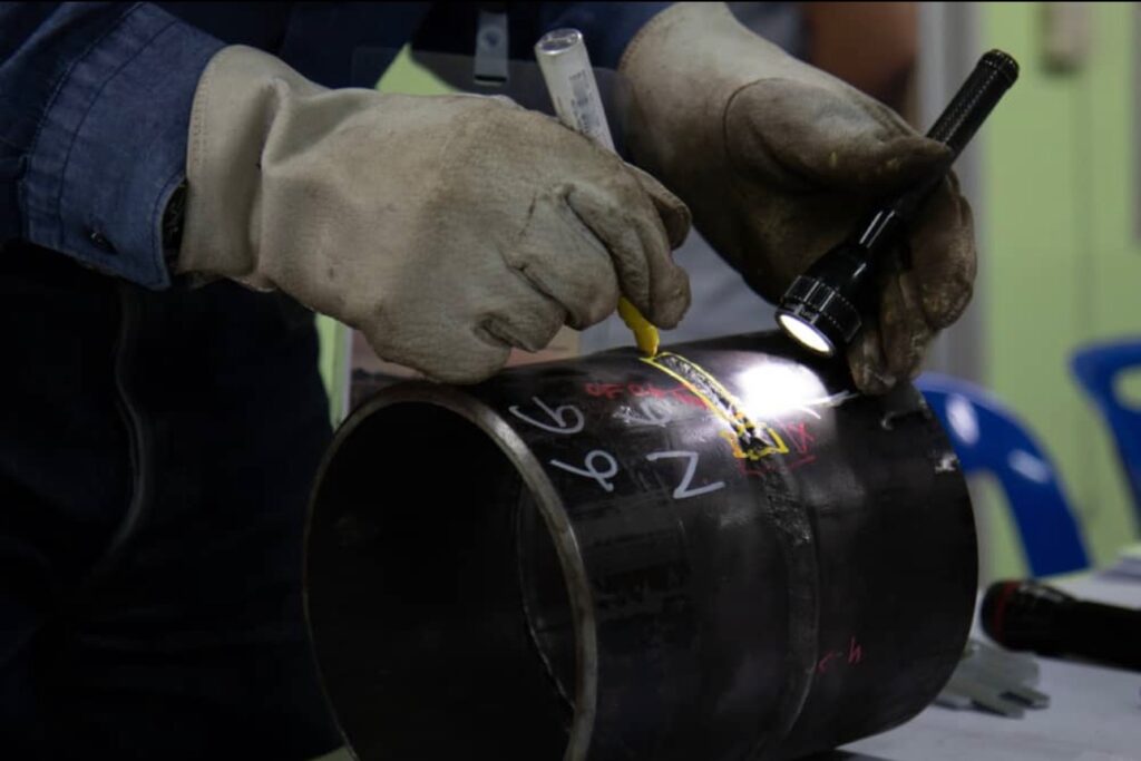 Man writing in market on material holidng flashlight